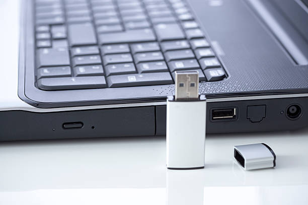 stik usb dan laptop, kedalaman bidang yang dangkal dengan fokus satu colokan USB. Cara Mengatasi Flashdisk Tidak Terbaca di PC atau Laptop (Foto: iStockphoto/Klikkoran)