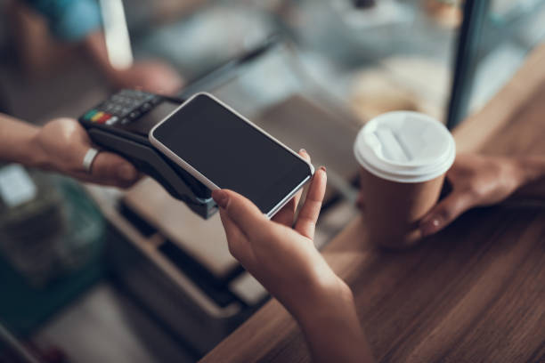 Wanita progresif yang berhati-hati dengan manikur memegang ponsel cerdasnya di atas mesin pembayaran kartu kredit saat menggunakan sistem pembayaran tanpa kontak.
Apa Itu NFC? Ini Penjelasan Fitur NFC, Fungsi serta Cara Penggunaannya (Foto: iStockphoto/Kl