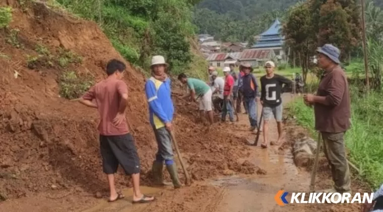 Masyarakat tengah membersihkan badan jalan tertimpa longsor di Agam. (Foto: AMCNews)