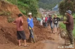 Masyarakat tengah membersihkan badan jalan tertimpa longsor di Agam. (Foto: AMCNews)
