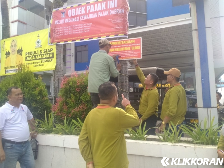 Bapenda Kota Padang bersama SK-4 kembali memasangkan stiker, yang telah dibongkar oknum tidak bertanggungjawab. (Istimewa)