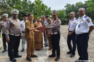 Dirlantas Polda Riau, Kombes Taufiq Lukman saat penyerahan bibit pohon kepada pihak sekolah SMKN 7 Pekanbaru