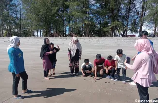 Pengunjung objek wisata konservasi penyu di Pariaman sedang melepas anak penyu ke laut.