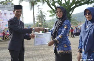 Wabup Yulian Efi Serahkan Piagam kepada Salah Seorang ASN Selesai Upacara Hardiknas