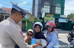 Personel Unit Kamsel Satlantas Polres Tulungagung saat membagikan pamflet kepada salah satu warga pengguna jalan