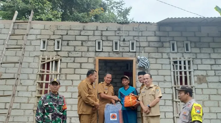 Wabup Ahmad Baharudin didampingi Kalaksa BPBD Tulungagung Robinson Nadeak Camat Ngantru dan Kades Padangan serahkan bantuan kepada warga terdampak bencana