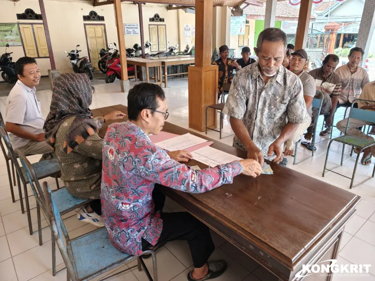 Kades Sidem Guritno (baju putih) menyaksikan penyerahan Insentif ketua RT dan RW di balai desa setempat