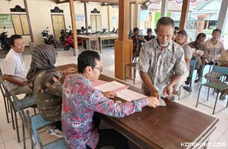 Kades Sidem Guritno (baju putih) menyaksikan penyerahan Insentif ketua RT dan RW di balai desa setempat