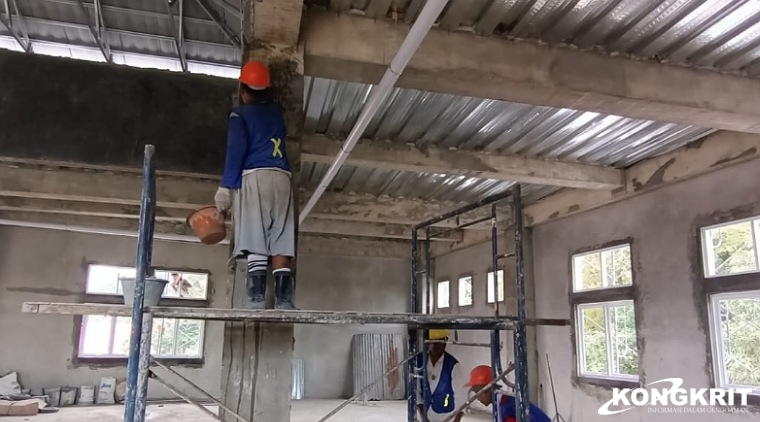 Pekerja dengan kelengkapan APD memperbaiki beton yang keropos (Afwerking), Sabtu (2/12/2023).