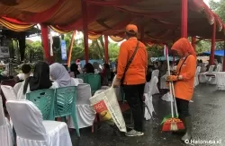 Pasukan oranye sedang membersihkan lokasi event Festival Muaro Padang