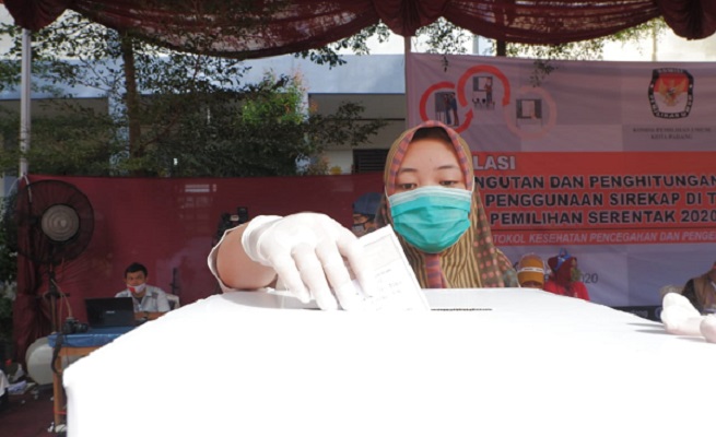 Warga memasukkan surat suara ke kotak suara saat simulasi pemilihan, Sabtu (21/11/2020). | Foto: Halbert Chaniago/Halonusa