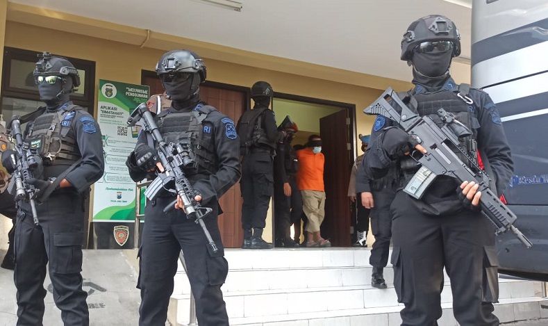 Anggota Brimob Polda Jatim bersenjata lengkap mengawal pengiriman 22 terduga teroris ke Jakarta, Kamis (18/3/2021). (Foto: iNews.id/Rahmat Ilyasan).