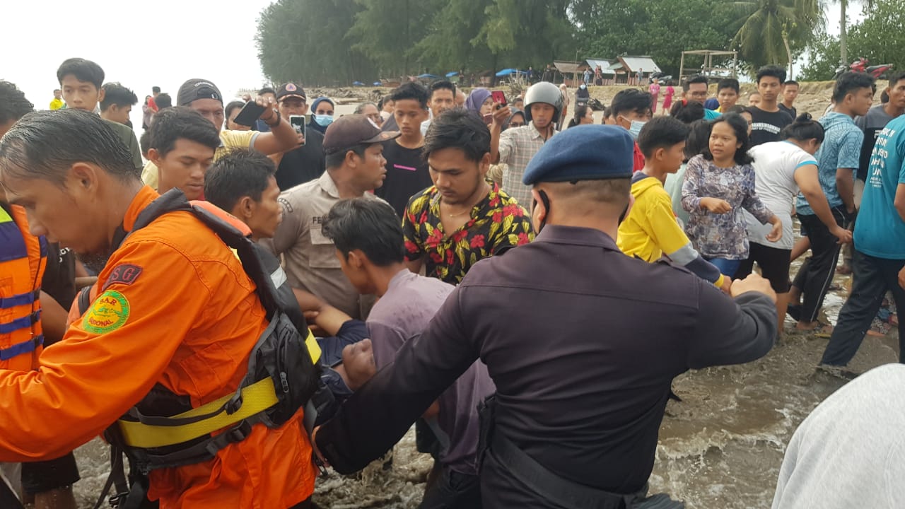 Petugas gabungan dibantu warga membantu mengevakuasi salah seorang wisatawan yang terseret ombak di Pantai Pasir Jambak. (Foto: Dok. Kantor SAR Padang)
