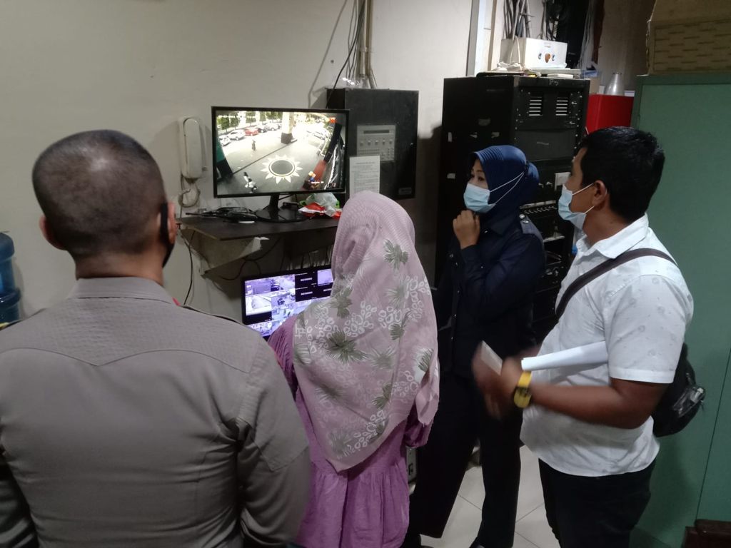 Polisi memeriksa rekaman kamera pengawas bersama N, 23 tahun yang membuat laporan palsu. (Foto: Dok. Polresta Padang)