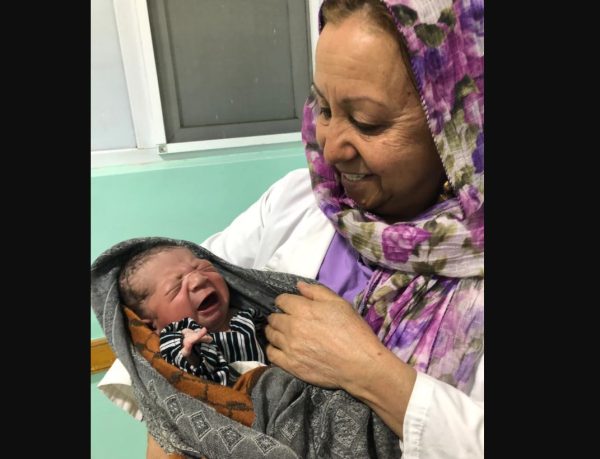 Fauzia Raouf, bidan senior di Rumah Sakit 100 Tempat Tidur, dengan seorang bayi laki-laki berusia beberapa jam. Seperti banyak rumah sakit umum, rumah sakit ini menghadapi kekurangan staf dan obat-obatan. (Pamela Constable/The Washington Post)