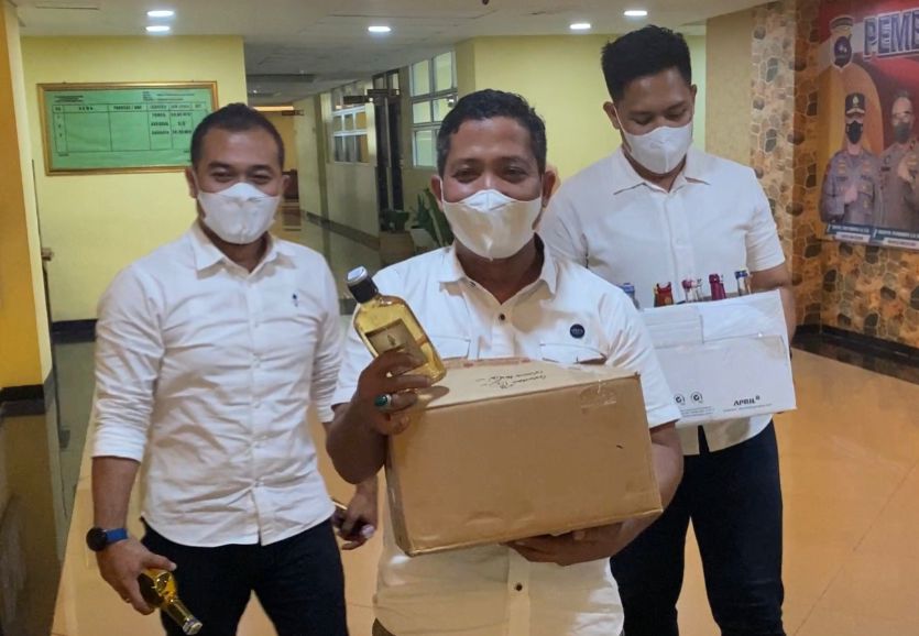 Tiga personel Ditreskrimsus Polda Sumbar mengangkut barang bukti (BB) minuman keras (miras) ilegal di Kota Padang. (Foto: Dok. Istimewa)