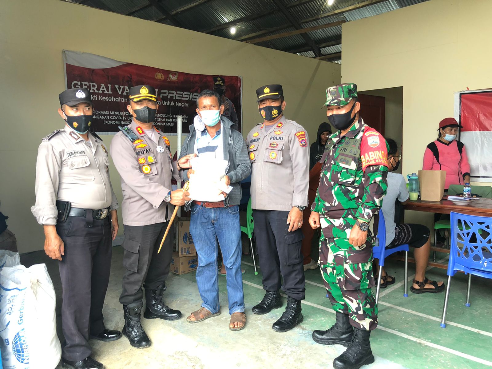 Kapolres Kepulauan Mentawai, AKBP Mu'at memberikan bingkisan kepada warga yang mengikuti vaksinasi Covid-19. (Foto: Dok. Polres Kepulauan Mentawai)