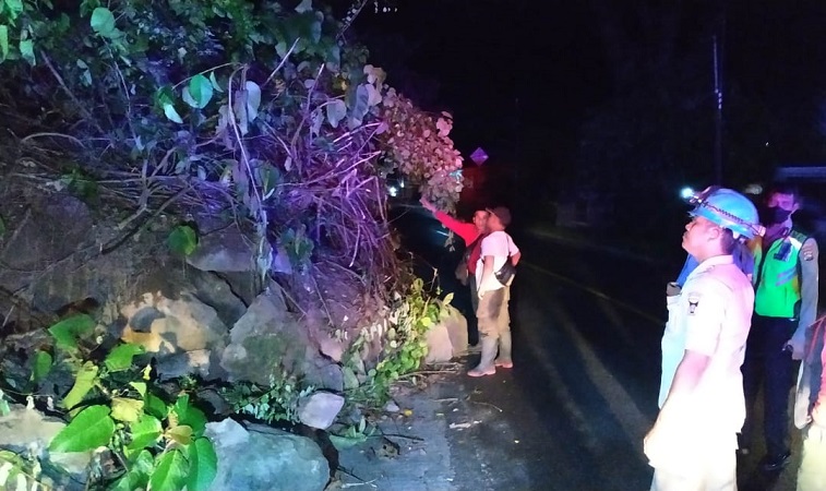 Petugas Tim Reaksi Cepat BPBD Kota Padang mengevakuasi bebatuan akibat longsor yang terjadi di jalan lintas Padang-Pessel. (Foto: Dok. BPBD Kota Padang)