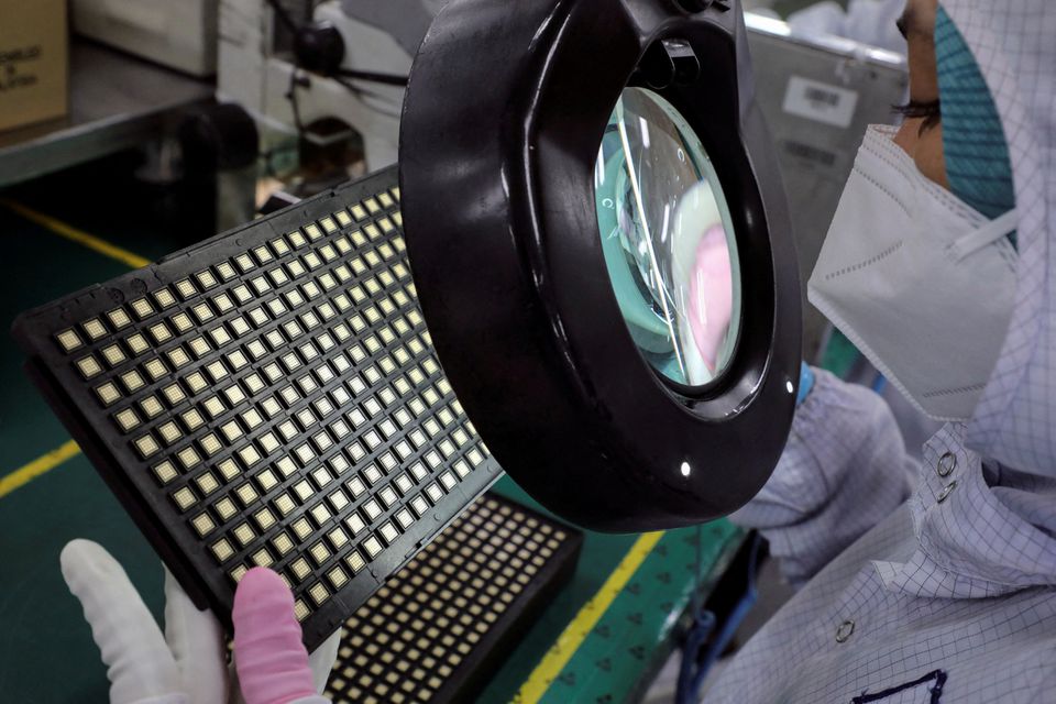 Seorang pekerja memeriksa chip semikonduktor di pabrik pengemasan chip Unisem (M) Berhad di Ipoh, Malaysia, 15 Oktober 2021. REUTERS/Lim Huey Teng/File Photo