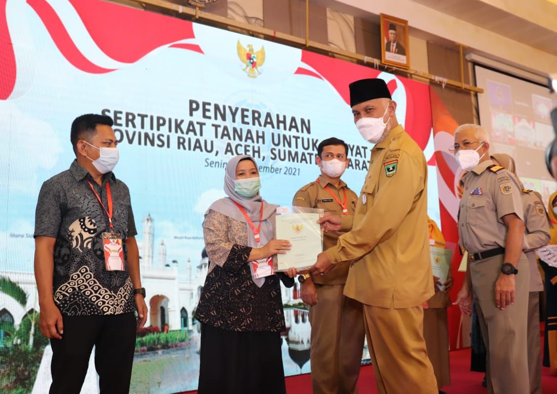 Gubernur Sumatera Barat Mahyeldi didampingi Saiful, Kepala Kantor Wilayah (Kakanwil) Badan Pertanahan Nasional Sumbar membagikan sertifikat hak atas tanah masyarakat melalui program PTSL tahun 2021, saat agenda pertemuan bersama Menteri Agraria dan Tata R