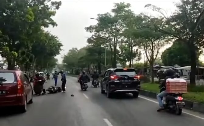Pengendara motor terjatuh di Jalan Arifin Achmad Pekanbaru, Selasa (4/1/2022) pagi. (Foto: istimewa)