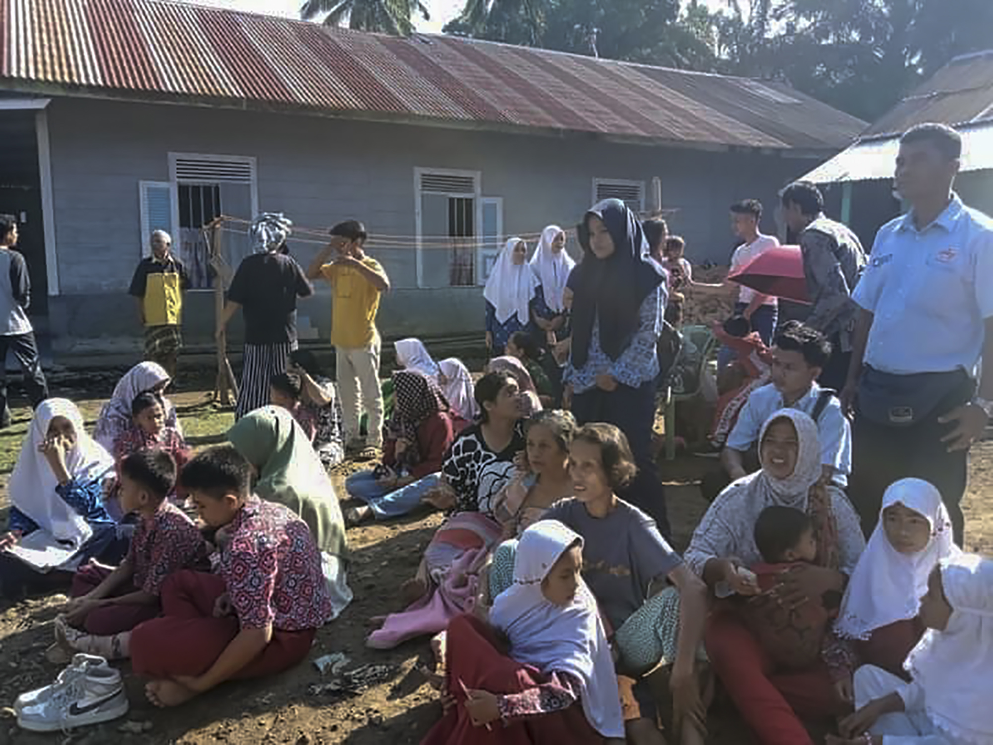 Menghindari reruntuhan rumah akibat gempa warga Pinariman, Desa Kajai, Kecamatan Talamau, Kabupaten Pasaman Barat, Sumatera Barat berkumpul di ruang terbuka, Februari 25, 2022. Idenfi Susanto for Halonusa