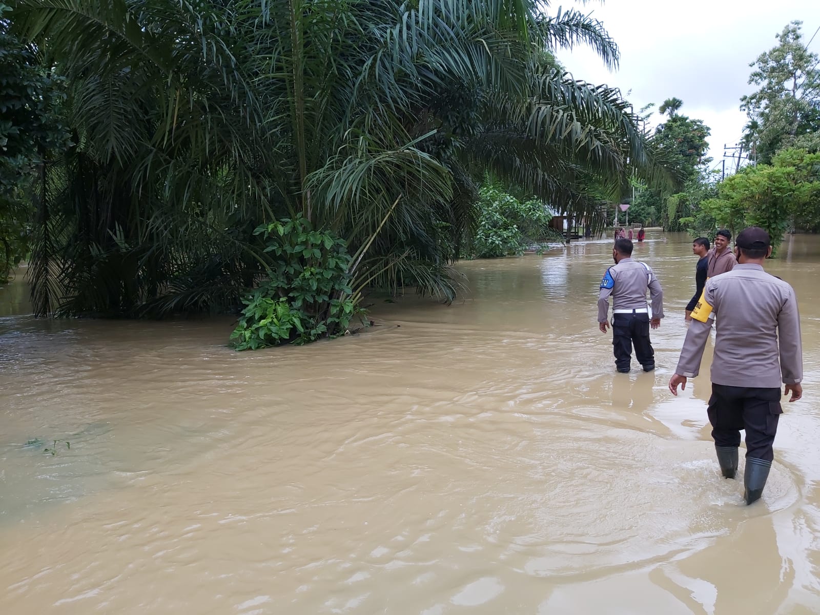 Petugas mencari mobil Irvan yang hilang terseret arus banjir. (Foto: Dok. Polsek Ranto Peureulak)