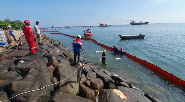 Petugas dari Pertamina saat mengatasi rembesan tumpahan minyak di laut Lhokseumawe, Senin (25/4/2022).