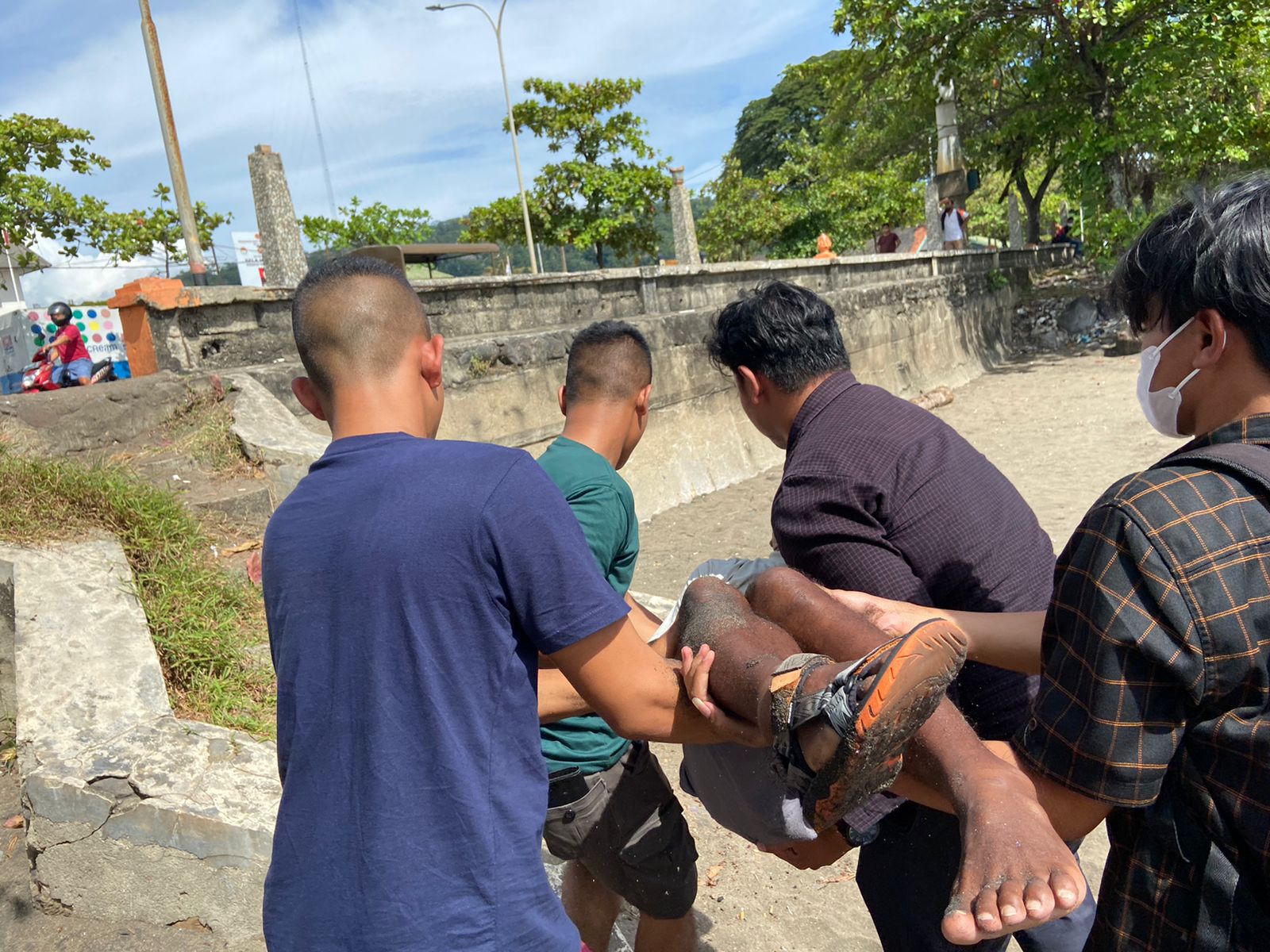 Warga mengangkat pria paroh baya yang tergeletak di Pantai Padang