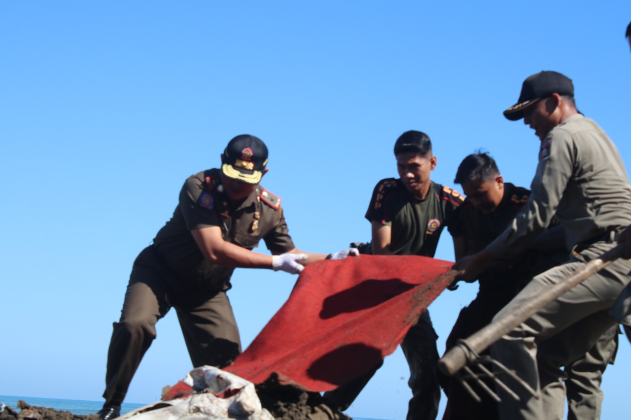 Personel Satpol PP padang membersihkan puing-puing PKL di Pantai Muaro Lasak