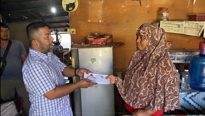 Pengurus DPD Gerindra Sumbar Hendra, Afnezola menyerahkan bantuan modal dan pembayaran tagihan PDAM bantuan dari Andre Rosiade kepada Ermiati di Ampang, Padang. (Foto: Dok. Tim AR)