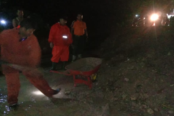 Petugas kebencanaan membersihkan tanah longsoran yang terjadi di kawasan Sungai Pisang, Kecamatan Bungus Teluk Kabung pada Kamis (1/9/2022) malam. (Foto: Istimewa/Dok. Pusdalops PB Padang)