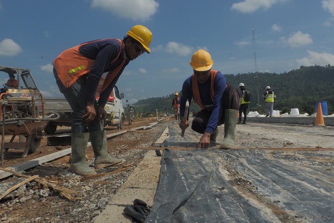 Pekerja sedang mengerjakan jalur tol Padang-Sicincin di jalur yang telah dibebaskan (Foto: Halbert Caniago)