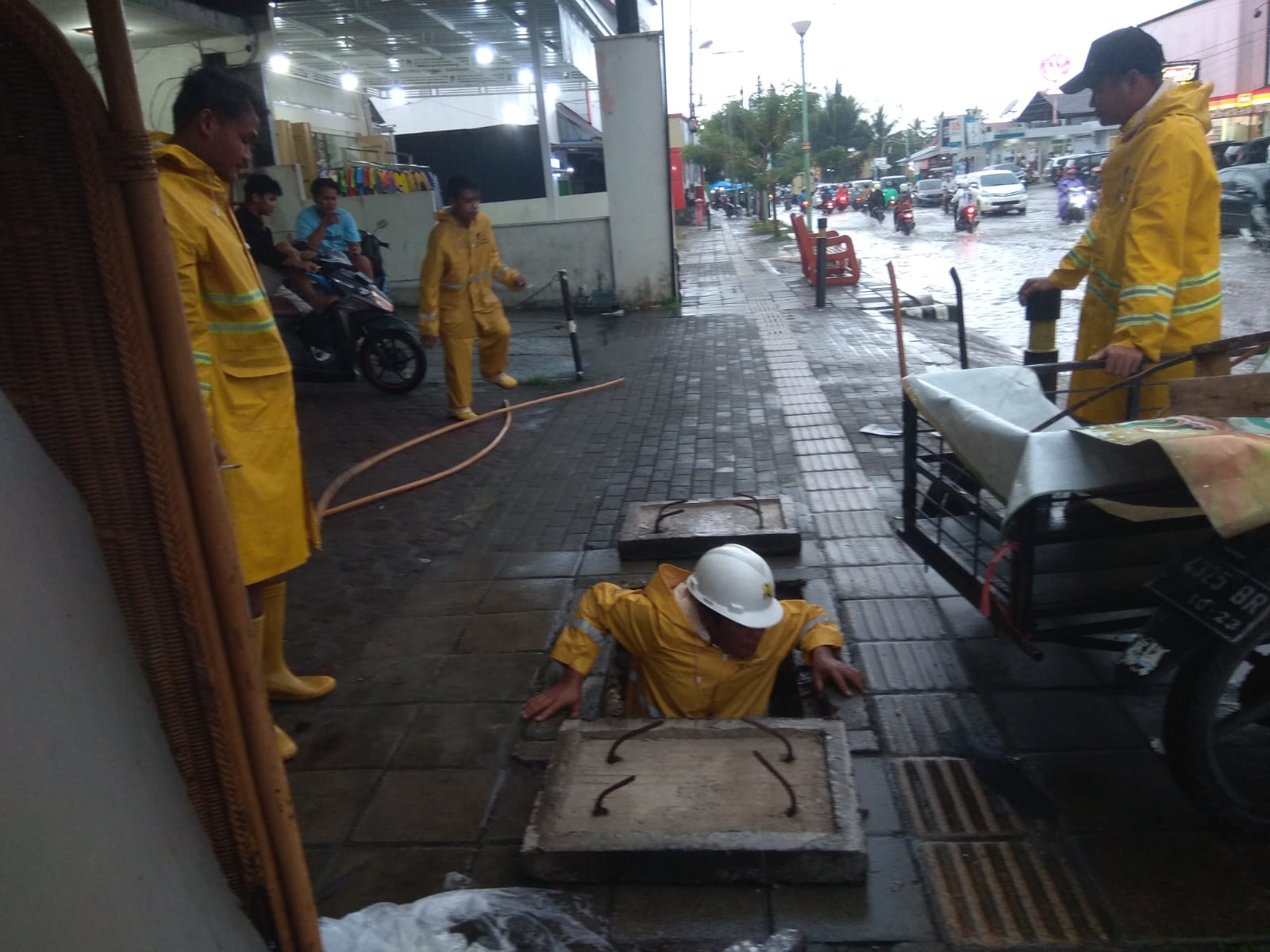 Seorang Personel Tim TRC Dinas PUPR Kota Padang Membenahi saluran drainase (Foto: Dokumentasi Dinas PUPR Kota Padang)