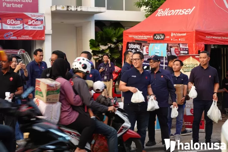 Direktur Sales Telkomsel, Adiwinahyu B. Sigit, berbagi makanan untuk warga sekitar di Jakarta (18/3) yang melintas di jalan menjelang waktu berbuka puasa.