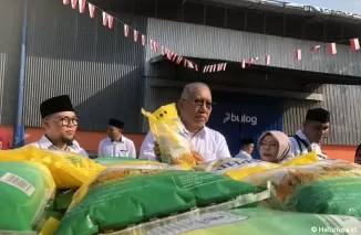 Direktur Utama Perum Bulog Bayu Krisnamurthi memperlihatkan beras yang akan didistribusikan.