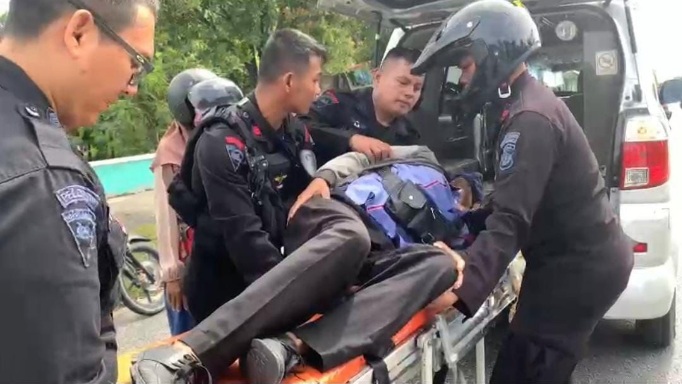 Foto Personel Brimob di Riau Bantu Warga Terkapar di Pinggir Jalan