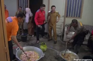 Petugas tengah memasak di dapur umum menyediakan makanan untuk warga korban bencana longsor dan banjir. Tampak penjabat Walikota Sawahlunto Fauzan Hasan melihat petugas gabungan sedang memasak.(armadison)