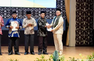 Menteri Nusron Wahid menyerahkan sertifikat kepada salah seorang pemilik ulayat pada Sosialisasi Pengadministrasian dan Pendaftaran Tanah Ulayat di auditorium Universitas Negeri Padang, Senin (28/4/2025). (ist)